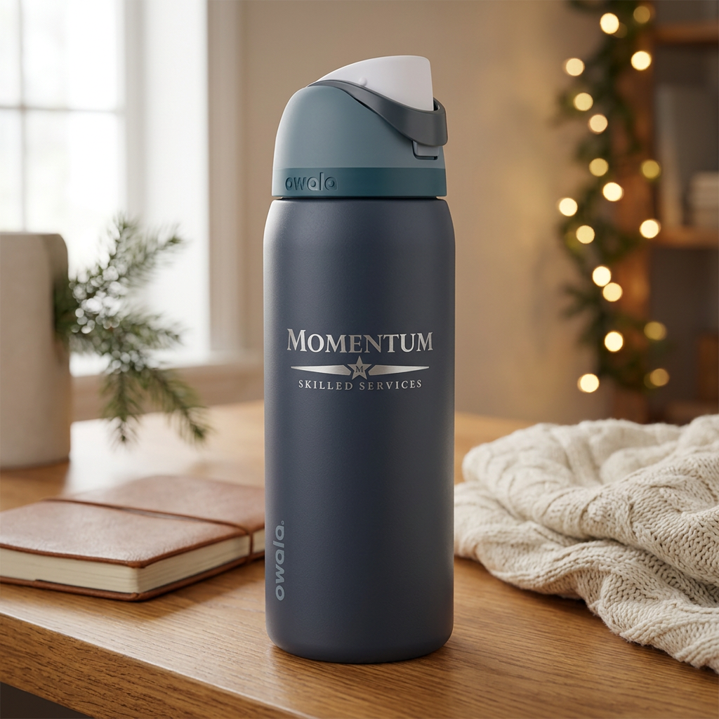 Owala Blue Steel bottle with Momentum logo in a cozy home office